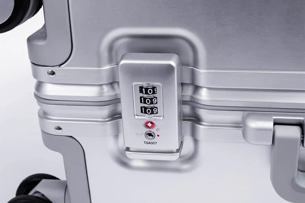 Nærbilde av TSA-lås og metallramme på ATHOS-kofferten.